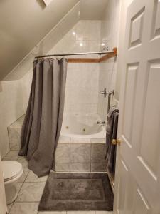 uma casa de banho com banheira e WC em Auberge Vue d'la Dune - Dune View Inn em Bouctouche