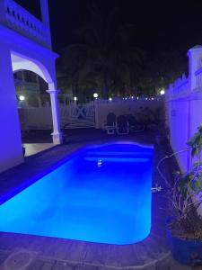 a swimming pool lit up in blue at night at Lacase Silverpalm in Pereybere
