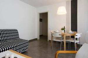 ein Wohnzimmer mit einem Tisch und einem Stuhl in der Unterkunft Cute tiny flat near the beach and city center in Tossa de Mar