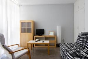 Zimmer mit einem Bett, einem Tisch und einem Stuhl in der Unterkunft Cute tiny flat near the beach and city center in Tossa de Mar