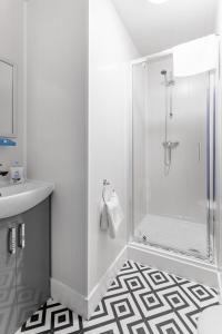 een witte badkamer met een douche en een wastafel bij City Centre Studio 1 with Kitchenette, Free Wifi and Smart TV with Netflix by Yoko Property in Middlesbrough