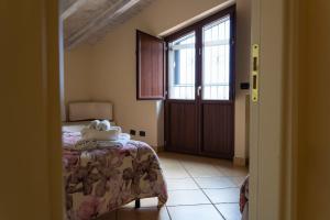 1 dormitorio con cama, ventana y puerta en Ranch Simeto, en Paterno
