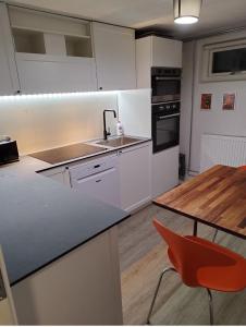 a kitchen with a sink and a table with a red chair at Louisiana Rent in Espergærde