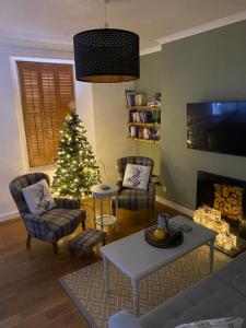 a living room with a christmas tree in front of a fireplace at Towerwell in Newburgh