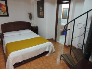 - une chambre avec un lit et une couverture jaune dans l'établissement Hotel Real, à Ocaña