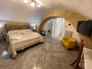 een slaapkamer met een bed en een tv. bij B&B DAMAPAGA Palazzo GRAPPA in Galatina