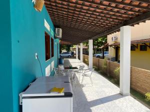 a patio with a blue building and a table and chairs at Japaraiso I Casa Azul - Próxima ao Mar in Japaratinga