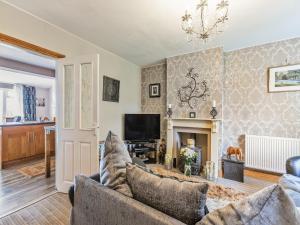 a living room with a couch and a fireplace at Flyby Cottage in Symonds Yat