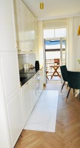 a kitchen with white cabinets and a view of the ocean at GOLD APARTMENT Piotrkowska 37 in Łódź