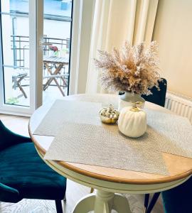 una mesa con un jarrón de flores encima en GOLD APARTMENT Piotrkowska 37, en Łódź