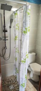 a bathroom with a shower curtain with a toilet at PITAYA in Ducos