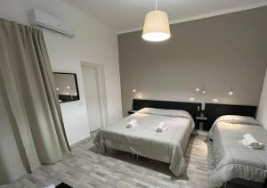 a hotel room with two beds and a light at La Maison in Acquaviva delle Fonti