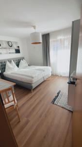 1 dormitorio con 1 cama y suelo de madera en Haus Laubreuter, en Kaprun