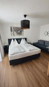 een slaapkamer met een groot bed en een bank bij Haus Laubreuter in Kaprun