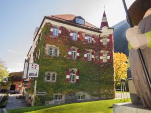 a large building with ivy on the side of it at Hotel Sachsenklemme in Fortezza