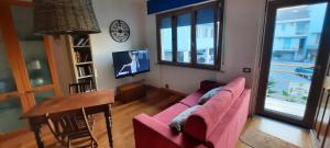 ein Wohnzimmer mit einem rosa Sofa und einem Tisch in der Unterkunft CasaMarina in Marina di Montemarciano
