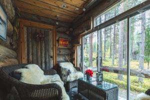 a living room with chairs and a table and windows at Hellevi in Levi