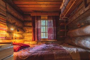 a bedroom with a bed in a log cabin at Hellevi by Aavalevi in Levi +8 photos