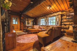 a living room with a couch and chairs in a log cabin at Hellevi by Aavalevi in Levi