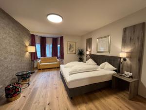 Habitación de hotel con cama y silla en Hotel Goldener Löwe, en Kufstein
