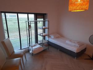 een slaapkamer met een stapelbed en een kamer met een raam bij villa the Tulip JULIA in Julianadorp