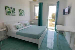 a bedroom with a bed and a window and a sink at Casamediterranea in Sperlonga