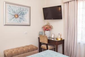 un soggiorno con tavolo, divano e TV di Hotel Hanan Deluxe ad Arequipa