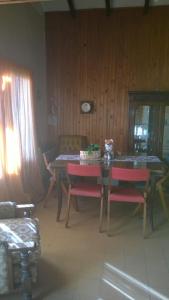 une salle à manger avec une table et des chaises rouges dans l'établissement Canela House, à Huerta Grande