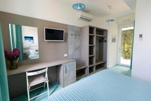 a bedroom with a bed and a tv on a wall at Casamediterranea in Sperlonga
