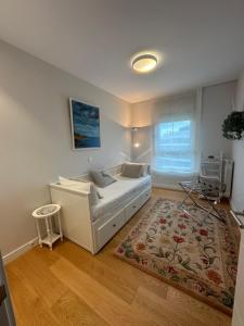 a living room with a white couch and a rug at A estrenar amplio con piscina y parking in Getxo