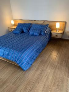 a bedroom with a blue bed with pillows and two lamps at Maravilloso chalet en la zona colonial (303) in Zipaquirá