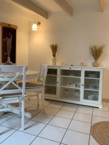 Aux Vieilles Murailles • Charmante maison & cour في مورليه: مطبخ مع طاولة وخزانة بيضاء