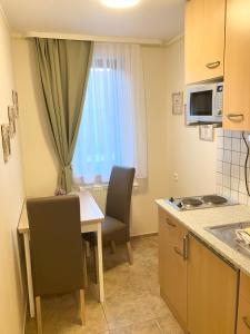 a small kitchen with a table and chairs and a window at Pension Sonja Müller in Nohra