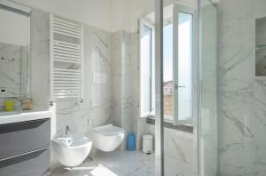 a white bathroom with a sink and a toilet at DIMORA SANTA CHIARA in Naples