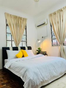 a bedroom with a large bed with yellow pillows at QV Residence Langkawi - Jacuzzi, BBQ, & Steamboat in Kuah