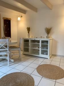 ein Wohnzimmer mit einem Tisch und einem weißen Schrank in der Unterkunft Aux Vieilles Murailles • Charmante maison & cour in Morlaix