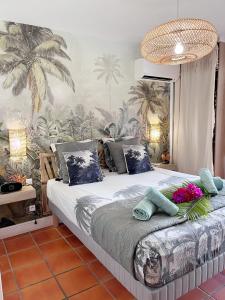 una camera da letto con un grande letto e carta da parati tropicale di KARIBEKO : Exceptionnel & Rare : Plage , Piscine, WiFi privé a Saint-François