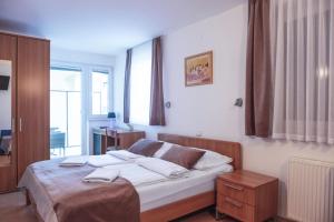 een slaapkamer met een bed met witte lakens bij Garni Hotel Keltika in Izola