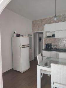 貝爾蒂奧加的住宿－Jdu Hostel e Bar，厨房配有白色冰箱和桌子
