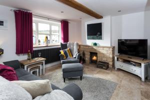 a living room with a couch and a fireplace at Forge Cottage in Winchcombe