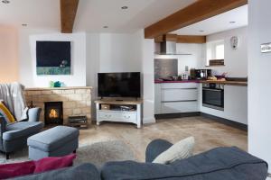 a living room with a couch and a fireplace at Forge Cottage in Winchcombe