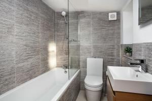 a bathroom with a toilet and a sink and a shower at Forge Cottage in Winchcombe +15 photos
