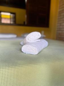 dos toallas blancas sentadas encima de una cama en Pousada Pacha Mama Village Bombinhas, en Bombinhas