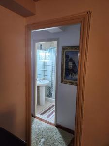 eine Tür, die zu einem Bad mit einem Waschbecken führt in der Unterkunft Habitación Elegante in Barcelona