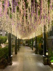 a walkway with hanging flowers and lights in a building at The Haven at One Eastwood Tower 1 in Manila