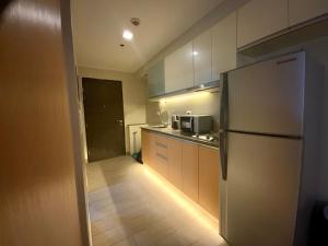 a kitchen with a refrigerator and a counter top at The Haven at One Eastwood Tower 1 in Manila