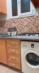 a kitchen with a washing machine and a window at Şişli harbiye kat iki in Istanbul