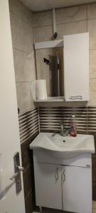 La salle de bains est pourvue d'un lavabo blanc et d'un miroir. dans l'établissement Midtown Hotel Apartments 301 (2+1), à Istanbul