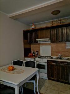 eine Küche mit einem Tisch und einem weißen Tisch und Stühlen in der Unterkunft Apartman Maki in Pale