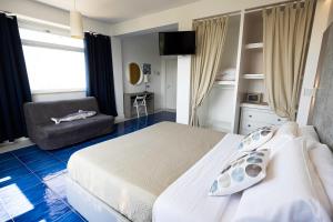 a bedroom with a white bed and a chair at Casamediterranea in Sperlonga